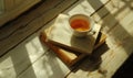 Stack of books with a cup of tea on a white table, window casting shadows Royalty Free Stock Photo
