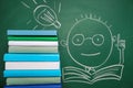Stack of books and drawn schoolboy on chalkboard Royalty Free Stock Photo