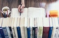 Stack of books education background, open book, female hand with pencil, glasses, and cup of tea with lemon Royalty Free Stock Photo