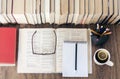 Stack of books education background, open textbook and notebook, glasses, pens and pencils in holder, cup of tea with lemon Royalty Free Stock Photo
