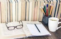 Stack of books education background, pencils, open book, glasses, and cup of tea with lemon Royalty Free Stock Photo