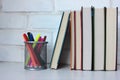 Stack of books and felt-tip pens on the table against white brick wall. Back to school background. Royalty Free Stock Photo