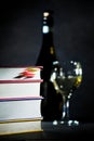 Stack of books with glass and bottle of white wine Royalty Free Stock Photo