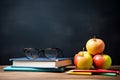 Stack of books with glasses and apples on blackboard background. Back to school concept, Glasses teacher books and a stand with Royalty Free Stock Photo