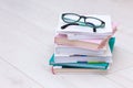 Stack of books with glasses on top. Concept cause of farsightedness, myopia