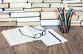 Stack of books, hardback books on wooden table, open book, notebook and glasses, copy space for text Royalty Free Stock Photo