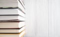 Book stack on white wooden table. Top view bright background of home library with space for text. World Book Day