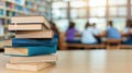Stack of books in a library with students studying in background Royalty Free Stock Photo