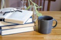 A stack of books lie on a wooden table. Nearby is a cup of coffee. horizontal background Royalty Free Stock Photo