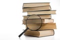 Stack of books with magnifying glass. Search information.