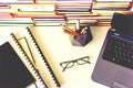 Stack of books, notebook, laptop, glasses in office background for education learning concept top view Royalty Free Stock Photo