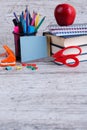 A stack of books, stationery, an apple and sheets on a wooden background. The concept of education. Royalty Free Stock Photo