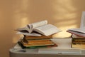 Stack of books with an open book with curved pages lies on the office desktop Royalty Free Stock Photo
