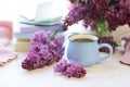 Stack of books, open notepad, pencils, cup of tea and fresh lilac flowers on wooden table, back to school concept Royalty Free Stock Photo