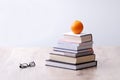 Stack of books with orange on top