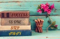 Stack of books over wooden table and motivational phrase