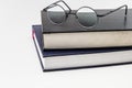 stack of books with a pair of eyeglasses o