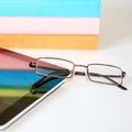 Stack of books with a pair of eyeglasses