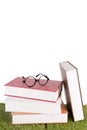 Stack of books with a pair of eyeglasses