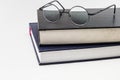 Stack of books with a pair of eyeglasses