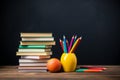 stack of books and pencils on school table against blackboard with an apple on top. Back to school concept, learning Royalty Free Stock Photo