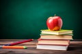 stack of books and pencils on school table against blackboard with an apple on top. Back to school concept, learning Royalty Free Stock Photo