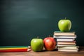 stack of books and pencils on school table against blackboard with an apple on top. Back to school concept, learning Royalty Free Stock Photo