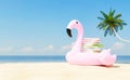 Stack of books placed on inflatable flamingo on sandy seashore