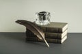 Stack of books and quill pen with inkwell on wooden table. Free copy space. Royalty Free Stock Photo