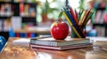 Stack of books, red apple and colorful pencils in case Royalty Free Stock Photo