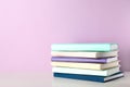 Stack of books on shelf against color background