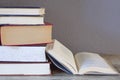 Stack of books sitting on a table with one open. Royalty Free Stock Photo