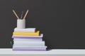 Stack of books and stationery in glass with black background Royalty Free Stock Photo