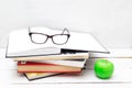 Stack of books for study and a green apple on a white background Royalty Free Stock Photo