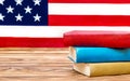 Stack of books on the table against american flag. American education. Space for text Royalty Free Stock Photo