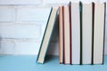 Stack of books on the table against white brick wall. Back to school background. Royalty Free Stock Photo