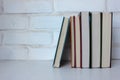 Stack of books on the table against white brick wall. Back to school background. Royalty Free Stock Photo