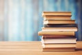 Stack of books on the table on blue background with copy space. AI generated Royalty Free Stock Photo