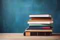 Stack of books on the table on blue background with copy space. AI generated Royalty Free Stock Photo