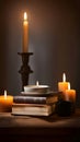 A stack of books on a wooden table with a cup of coffee and a candle, representing reading and relaxation Royalty Free Stock Photo