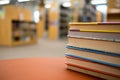 Stack of books on a wooden table in a library Royalty Free Stock Photo