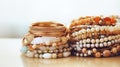 A stack of bracelets on a white surface and background. The bracelets are made of gold, pearls, beads, and gemstones Royalty Free Stock Photo