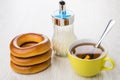 Stack of bread rings, yellow cup of tea, sugar bowl Royalty Free Stock Photo