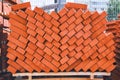 Stack of red building bricks close-up. Red bricks for laying at construction site. Brick wallpaper pattern Royalty Free Stock Photo