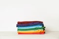 Stack of bright folded clothes on table Royalty Free Stock Photo