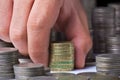 Stack of british pound coins with a male hand Royalty Free Stock Photo