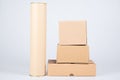 Stack of brown cardboard boxes with card board tube on white background Royalty Free Stock Photo