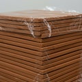 Stack of brown clay tiles wrapped in transparent plastic. The tiles are uniformly Royalty Free Stock Photo