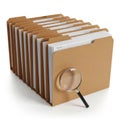 Stack of brown file folders with documents and magnifying glass isolated on white background Royalty Free Stock Photo