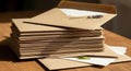 Stack of brown kraft envelopes on a wooden table, with one envelope open, Royalty Free Stock Photo